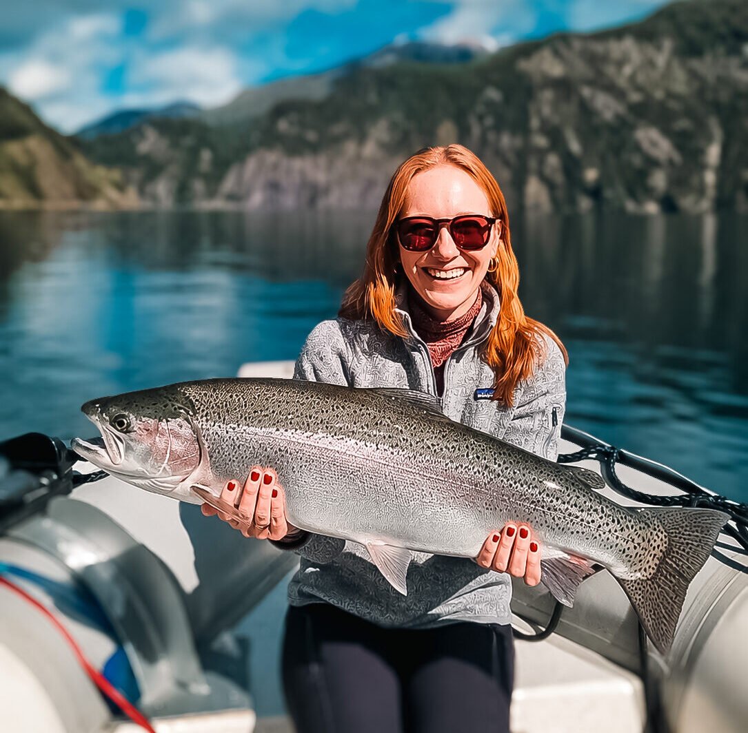Woman fly fishing Bariloche Argentina with a giant rainbow trout