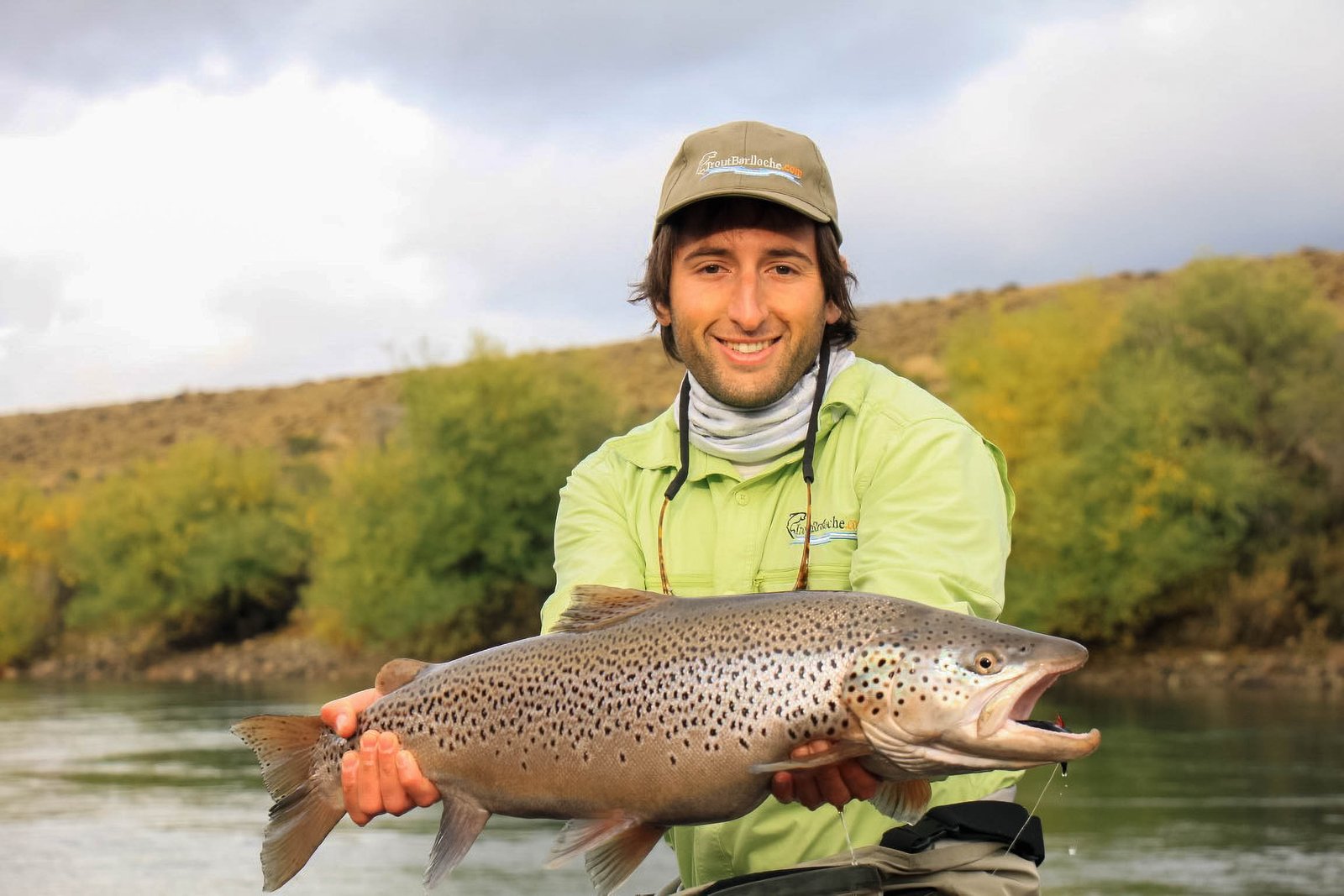 Young Emanuel Medina guiding for Trout Bariloche, holding a giant trout caught fly fishing in Bariloche, Patagonia, Argentina